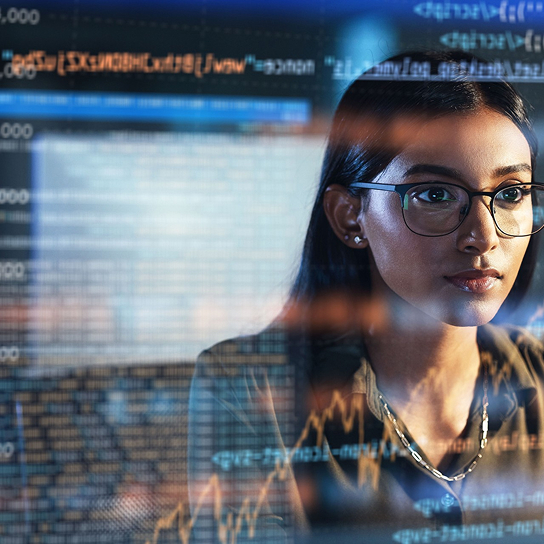 the reflection of a woman checking operations on a computer screen
